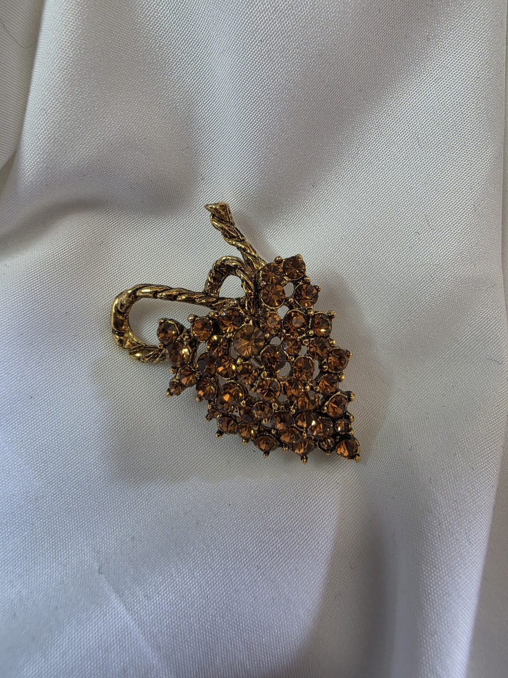 Vintage Gold Tone Brooch of Amber Rhinestoned Grape Bunch with Twisted Stem.
